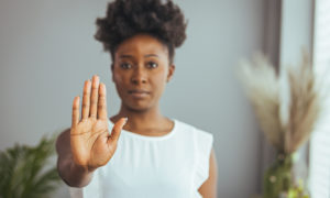 Serious businesswoman gesturing stop sign | hoa signs